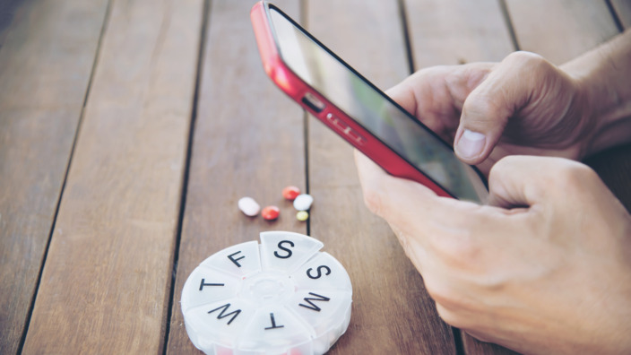 Smartphone fotografiert eine Tablettenschachtel. 