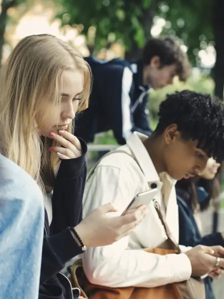 Zwei Jugendliche schauen auf ihr Smartphone