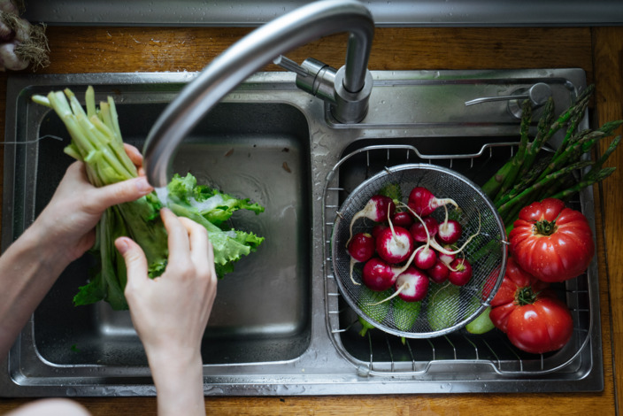 Saisongemüse wie Radieschen und Tomaten in Sieb in Spüle