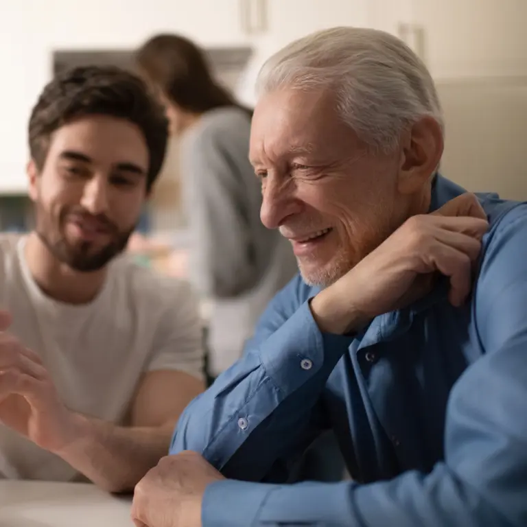 Junger Mann zeigt älteren Herren etwas auf seinem Smartphone.