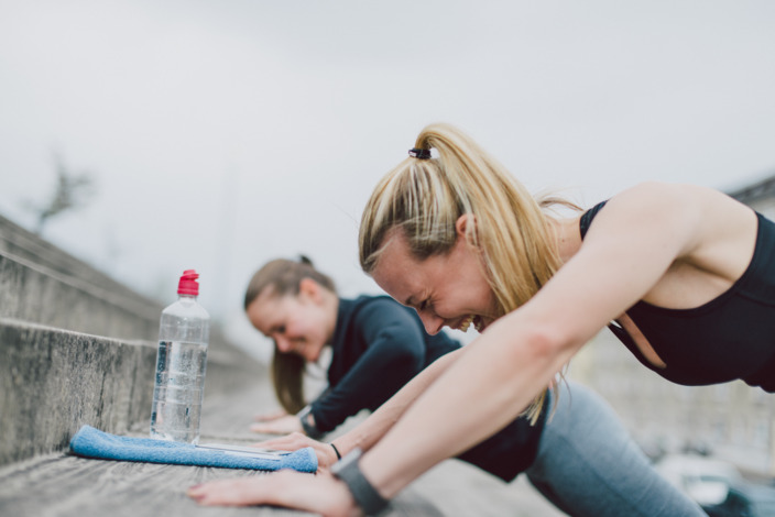 Freundinnen machen Push-ups draußen und haben Spaß