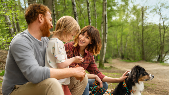 Familie mit Hund am Seeufer