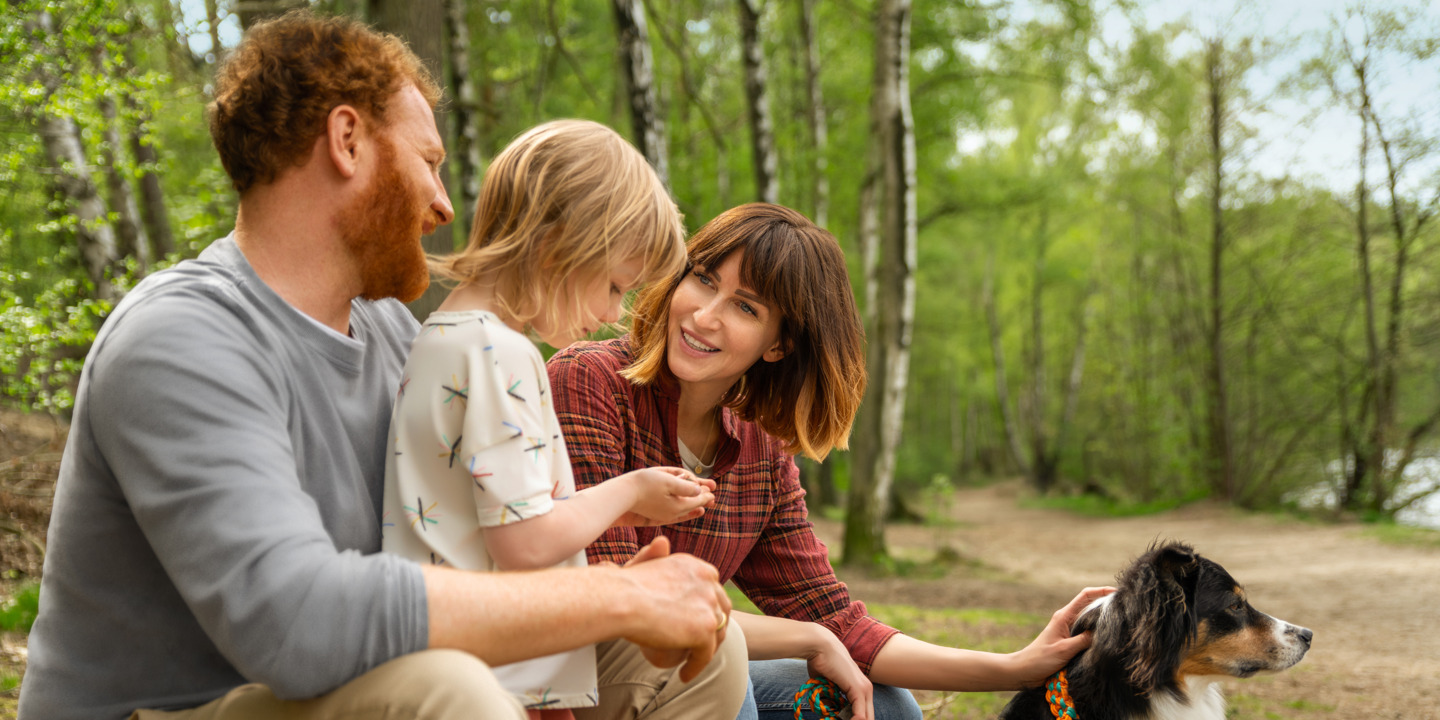 Familie mit Hund am Seeufer