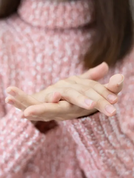 Frau cremt sich ihre Hände ein