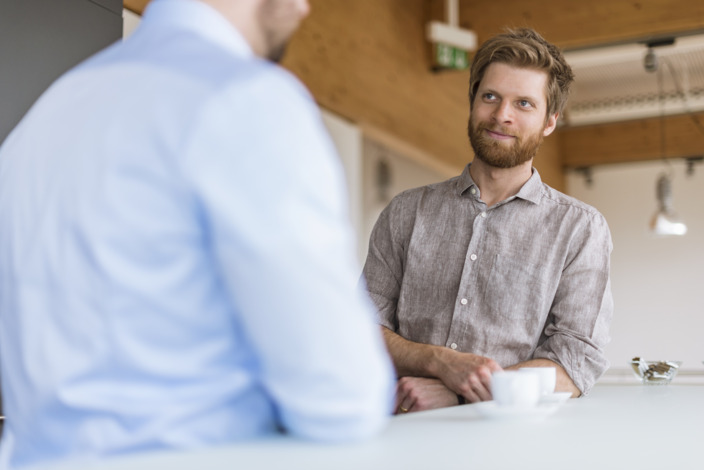 Führungskraft spricht mit Mitarbeiter im Büro