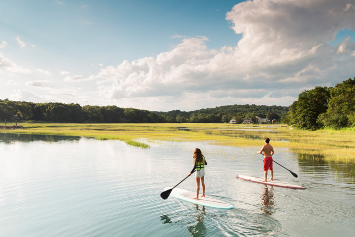 Junge Frau und Mann auf Stand up Paddle am See