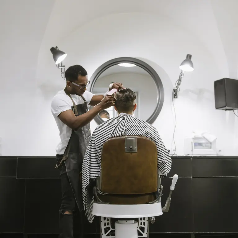 Friseur schneidet Kunden die Haare im Friseursalon