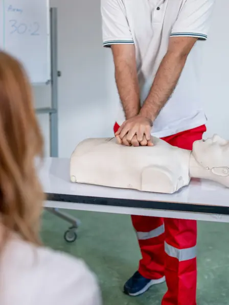 Rettungssanitäter demonstriert eine Herzmassage an einer Erste-Hilfe-Puppe
