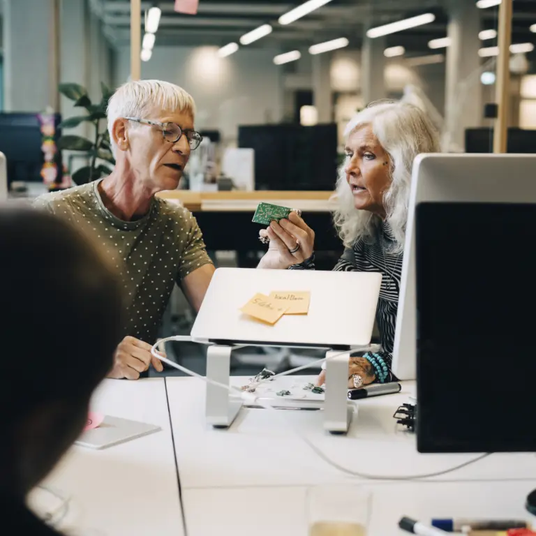 Zwei ältere Personen arbeiten im Büro zusammen