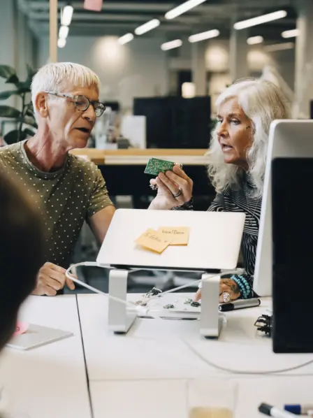 Zwei ältere Personen arbeiten im Büro zusammen