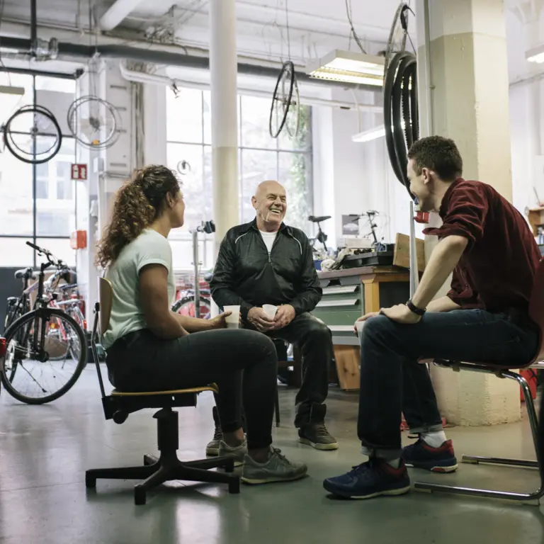Gruppe von Fahrradmechanikern bespricht sich in der Werkstatt