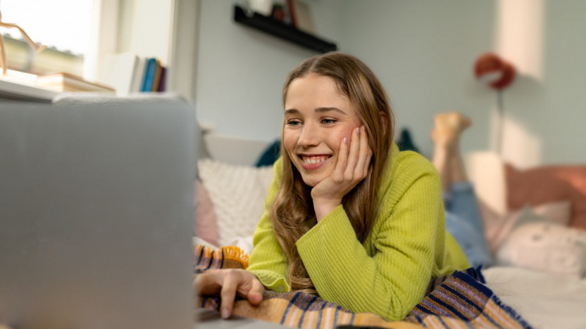 Mann und Frau sitzen am Laptop und lachen