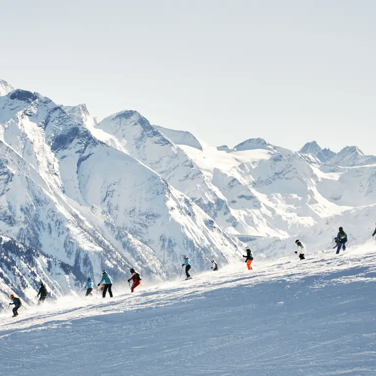 Gruppe von Skifahrern vor Bergkulisse
