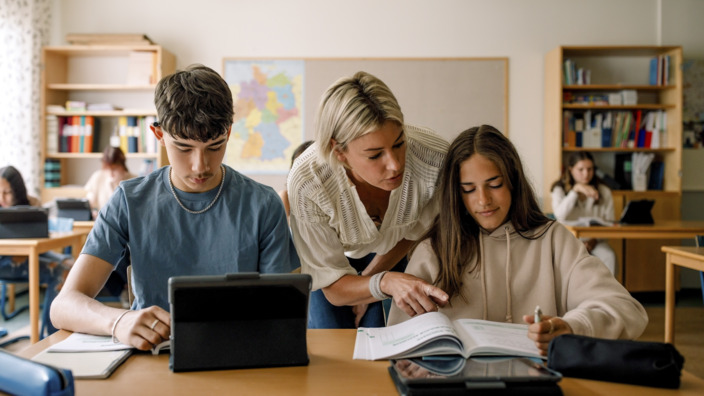 Teenies und eine Lehrerin in einem Klassenzimmer