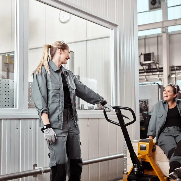 Zwei Frauen arbeiten zusammen in Lagerhalle.