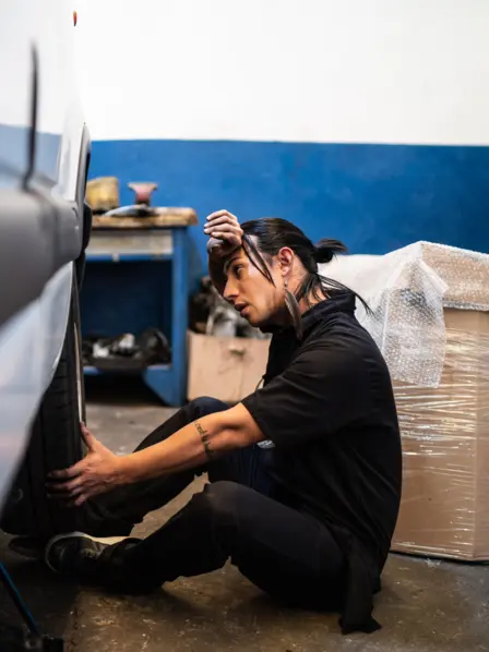 Mann erschöpft in Autowerkstatt