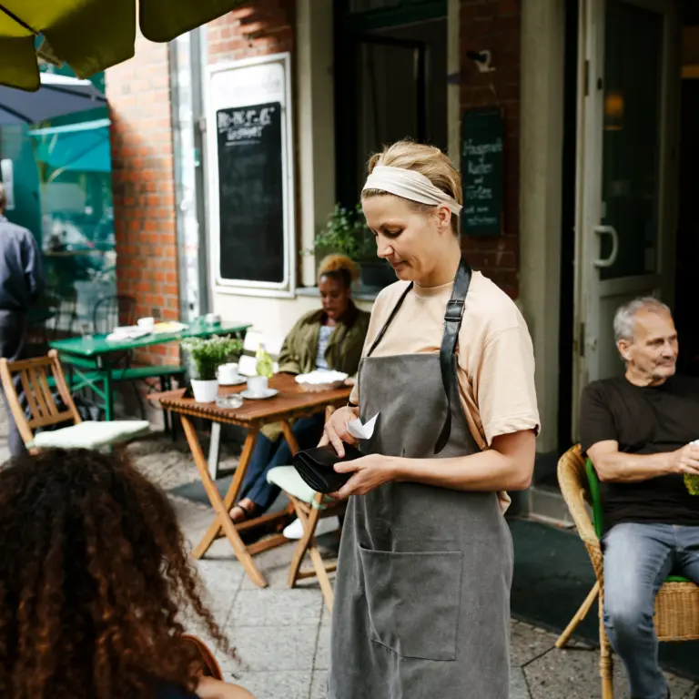 Bedienung gibt im Cafe Wechselgeld raus