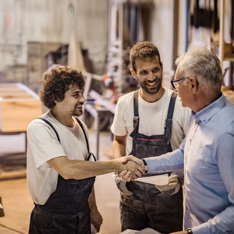 Zwei Handwerker im Gespräch mit einem Kunden