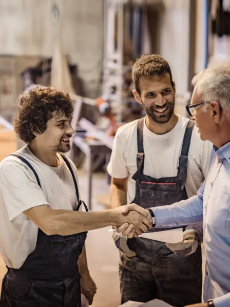 Zwei Handwerker im Gespräch mit einem Kunden
