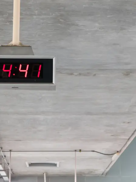 Digitale Uhr hängt von einer Beton-Decke