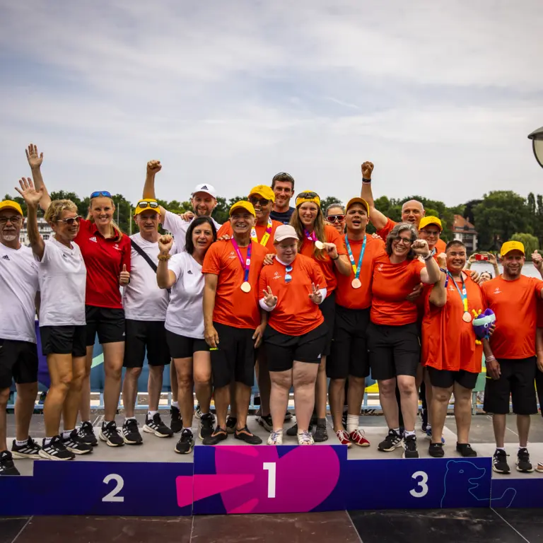 Sportlerteam auf dem Siegertreppchen.