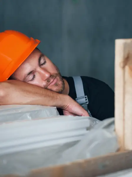 Handwerker mit Helm macht Mittagsschlaf
