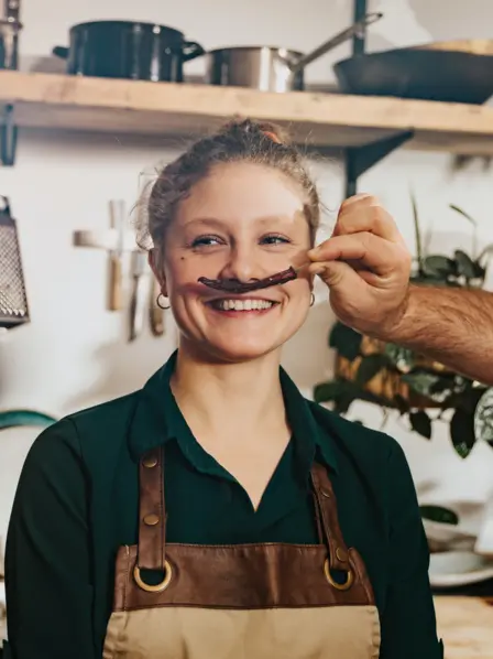 Frau wird eine Chilischote unter die Nase gehalten.