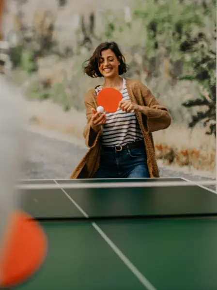 Lachende Frau spielt Tischtennis