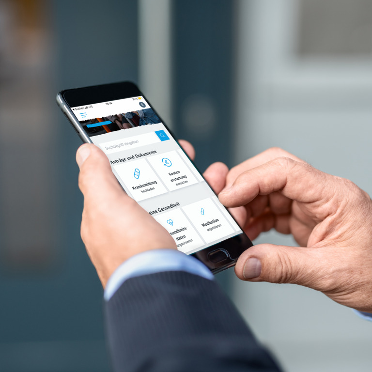 Ein Mann hält ein Handy in der Hand und scrollt durch eine App.