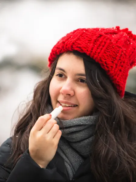 Frau pflegt ihre Lippen im Winter