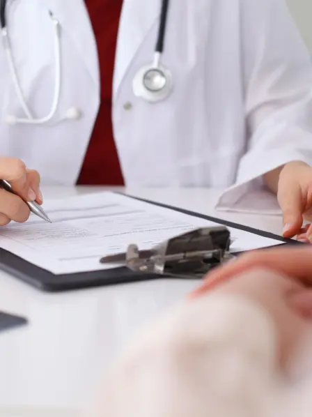 Arzt macht sich Notizen während eines Patientengesprächs