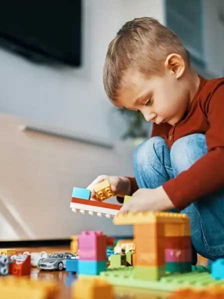 Ein kleiner Junge spielt mit bunten Bauklötzchen