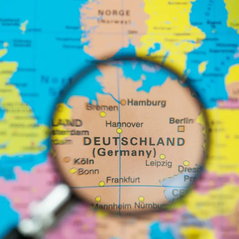 Weltkarte, auf der Deutschland mit einer Lupe vergrößert ist