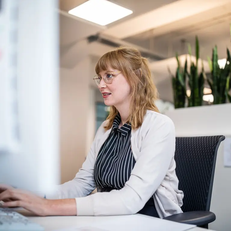 Frau, die im Büro am PC arbeitet