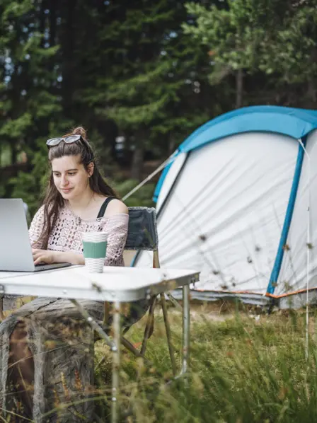 Eine Frau, die während dem Campingurlaub arbeitet