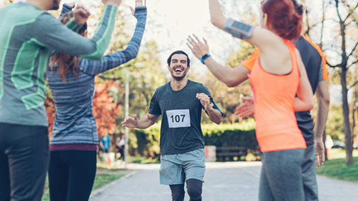 strahlender Mann beim Zieleinlauf einer Laufveranstaltung