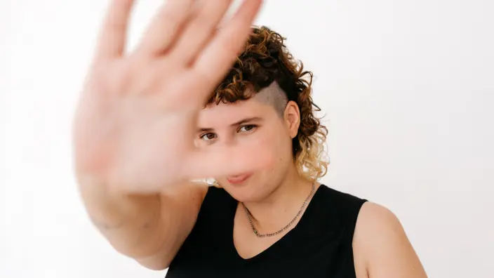 Eine Frau, die mit ihrer Hand ein "Stopp" signalisiert