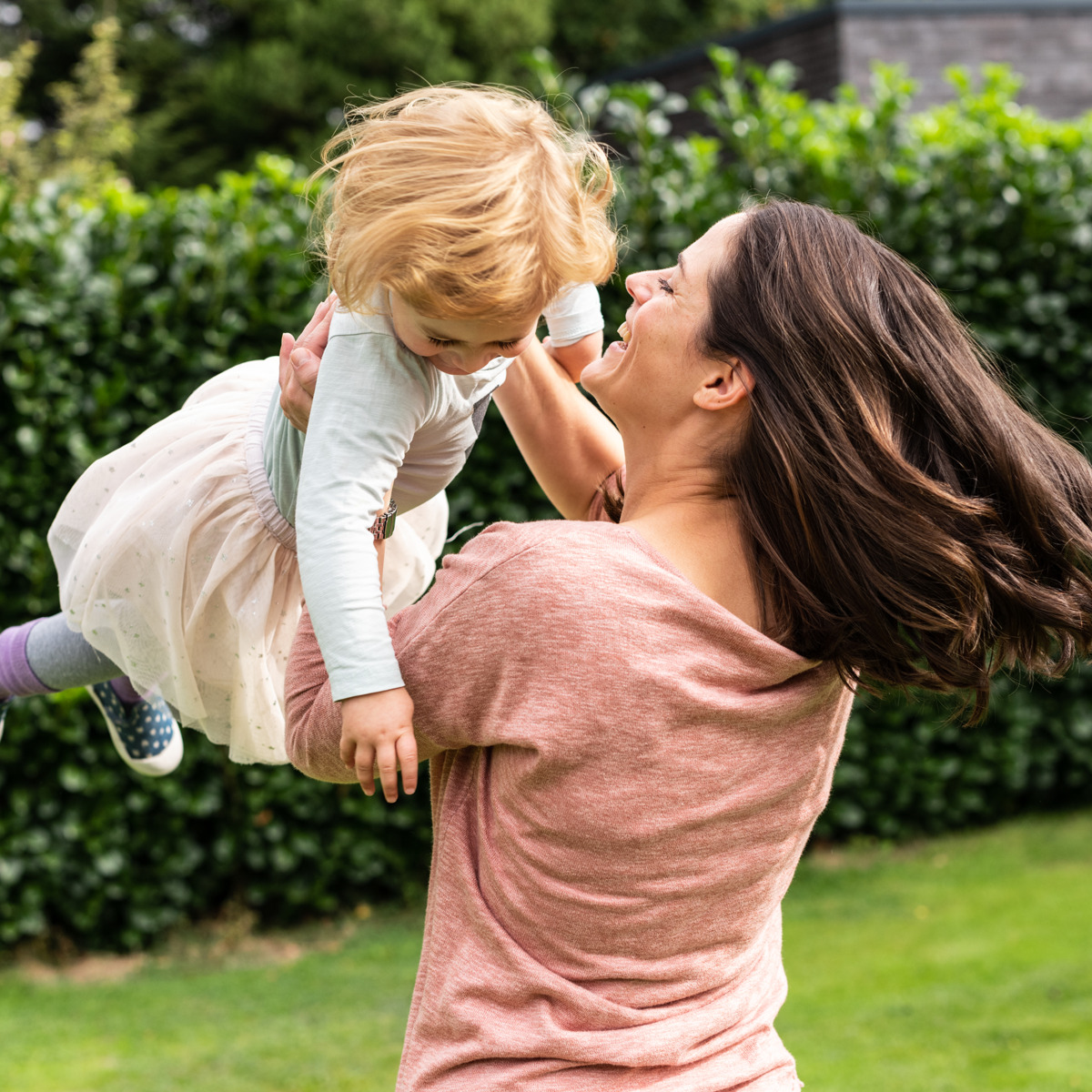 Mutter und Tochter spielen im Garten