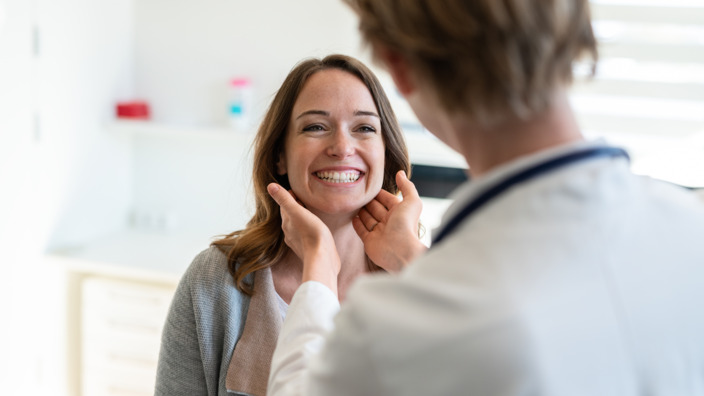 Ärztin tastet bei einer Patientin die Lymphknoten ab