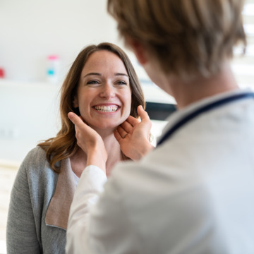 Ärztin tastet bei einer Patientin die Lymphknoten ab