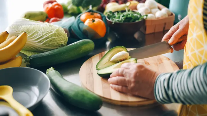 Person schneidet eine Avocado