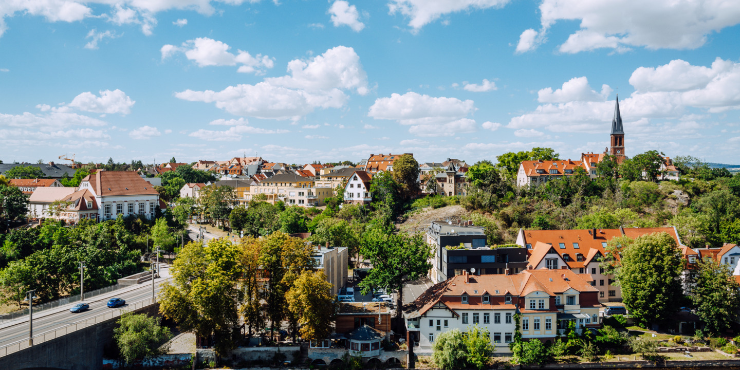 Blick auf eine Stadt im Grünen, die an einem Fluss liegt