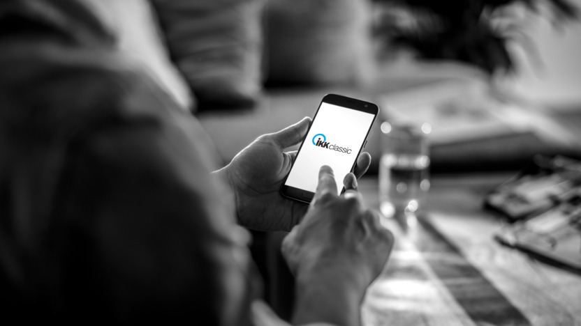 Mann hält ein Smartphone in der Hand mit dem IKK classic Logo auf dem Screen.