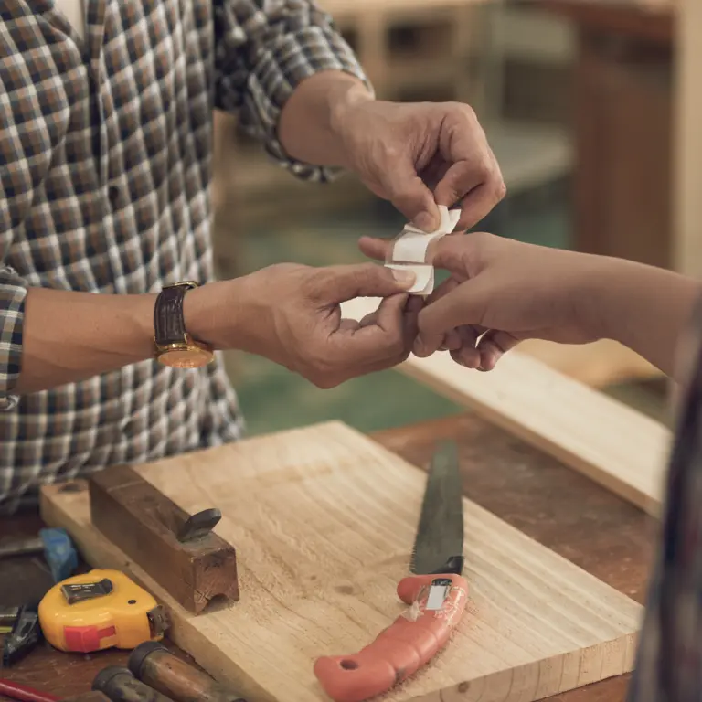 Ein Handwerker versorgt die Wunde seines Kollegen.