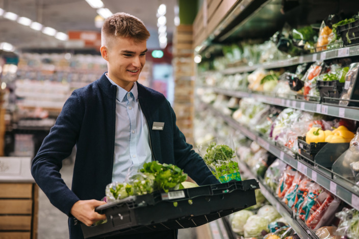 Junger Mann arbeitet im Supermarkt auf Minijob-Basis.