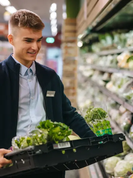 Junger Mann arbeitet im Supermarkt auf Minijob-Basis.