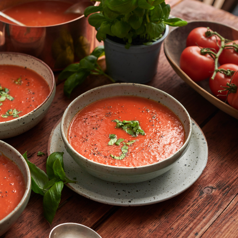 Tomatensuppe mit frischem Basilikum und Chili in einer Schale.