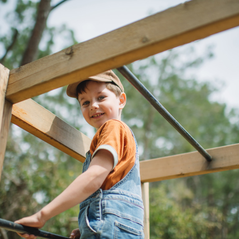 Kind spielt auf einem Klettergerüst.