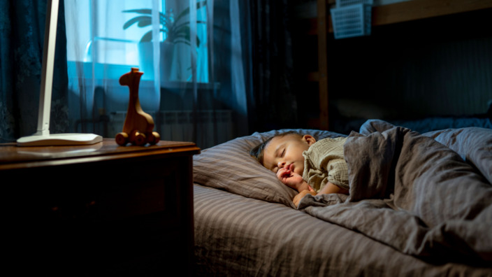 Kleinkind schläft friedlich im Bett 