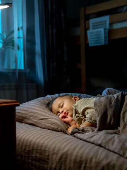 Kleines Kind liegt im Bett und schläft.